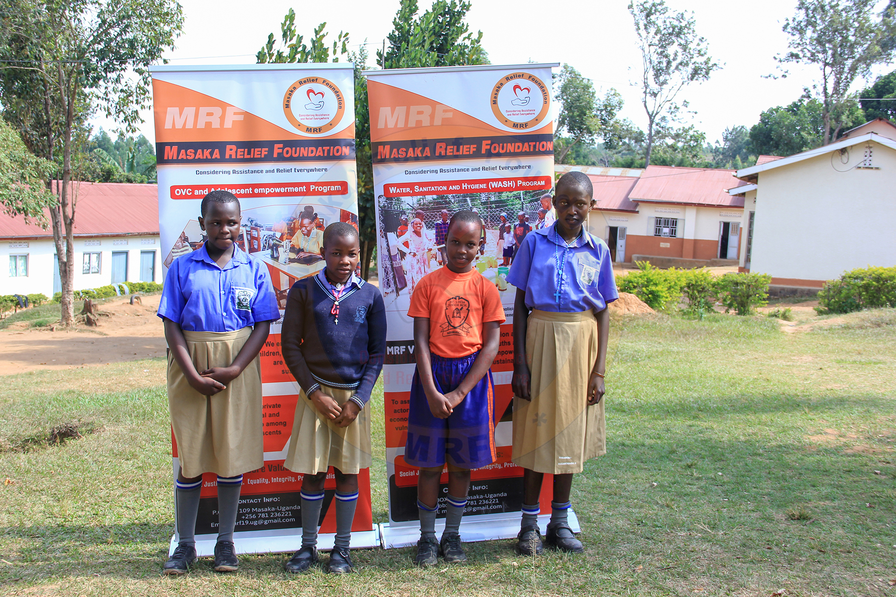 Outdoor community meeting with MRF banners at school